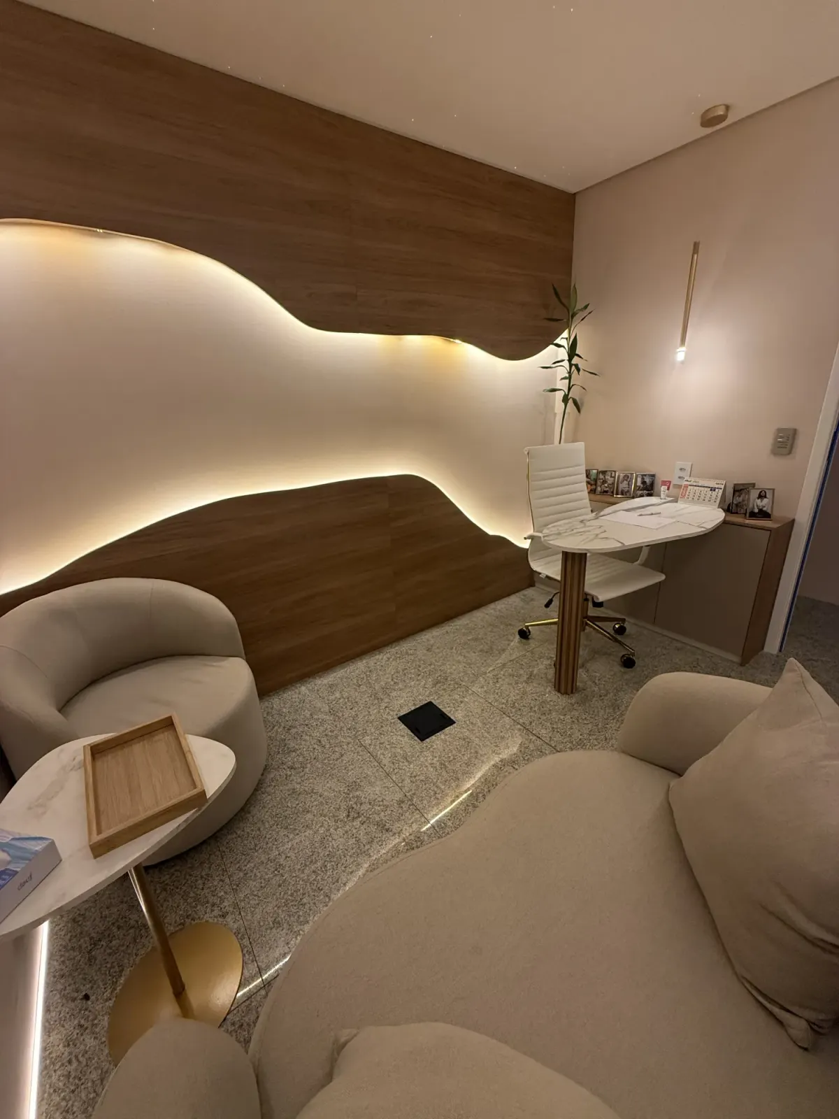 Sala de atendimento da VCare Essence em outro ângulo, com mesa e poltronas