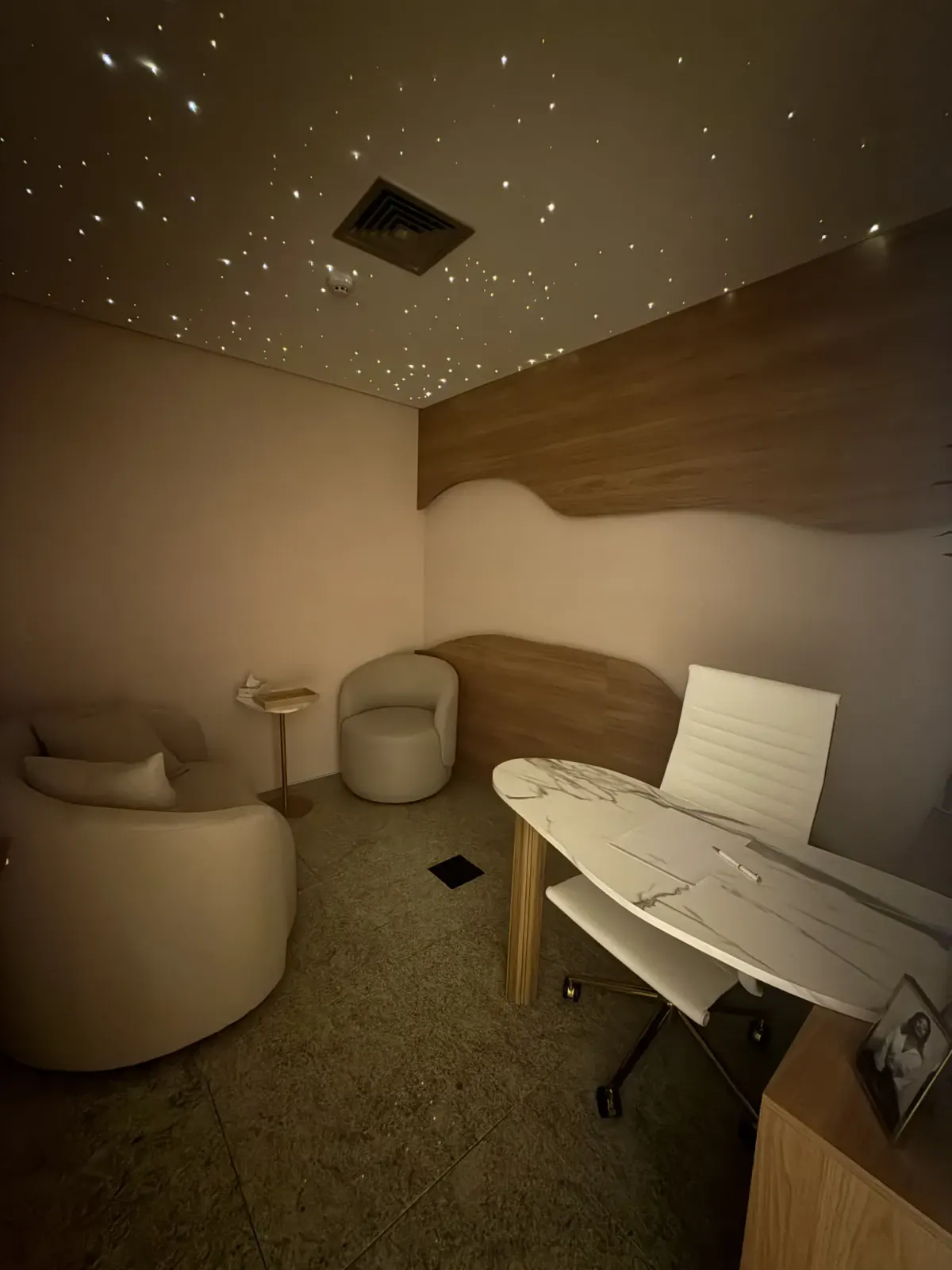 Sala de atendimento sob o céu estrelado em fibra óptica, com luz quente